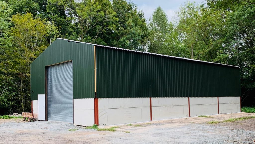 Storage Barn with green walls and a silver roller shutter door